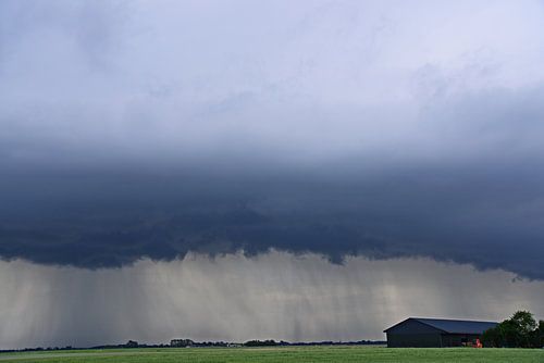 Rolwolk en neerslag bij een schuur