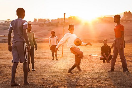 Eine Gruppe Kinder, die Fußball in Afrika spielen