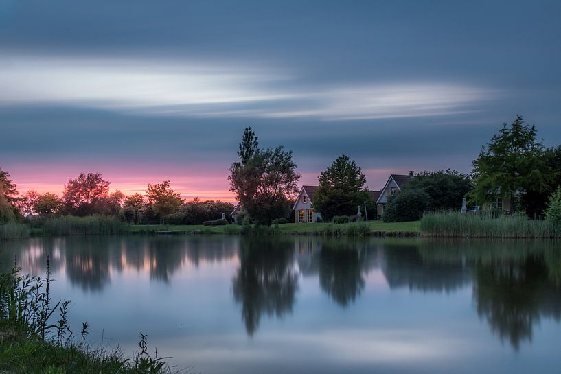 Zonsondergang in Emmen met spiegeling in de grote rietplas van Kim Bellen