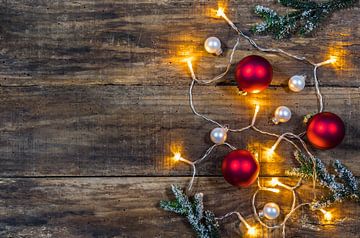 Hölzerner Weihnachtshintergrund mit Ornament, Tannenzweige und glänzendes Licht von Alex Winter