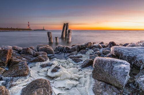Minimalistisch winterlandschap met ijs en palen in het IJsselmeer
