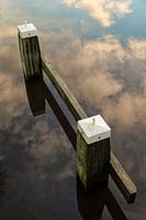 Meerpaal in een weerspiegeling van de wolken lucht in het water. One2expose Wout Kok Photography. 