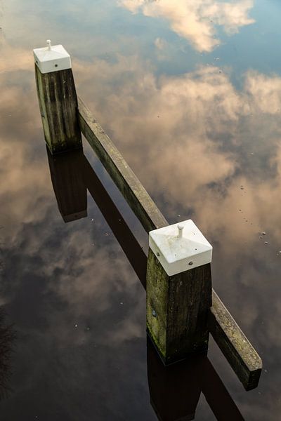 Seepfahl in einer Reflexion des Wolkenhimmels im Wasser. One2expose Wout Kok Fotografie.  von Wout Kok