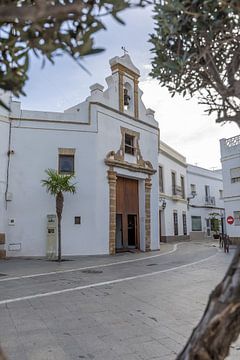 Kerk in een witte huisgevel, Iglesia de San Roque in Rota, Cadiz, Andalusië, Spanje. van Fotos by Jan Wehnert