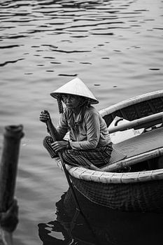 La femme du pêcheur est assise sur le bord de son panier.