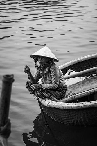 Fisherman's wife sits on the edge of her basket boat