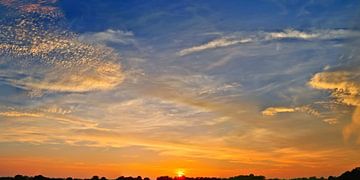 Beautiful high resolution panorama of orange and red sunset clouds in the evening sky. van MPfoto71