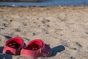 Rode schoenen op het strand