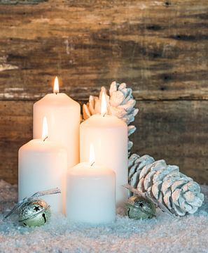 Kaarsvlammen in de advent- en kersttijd met witte en zilveren versiering van Alex Winter