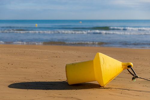 Yellow buoy on the beach
