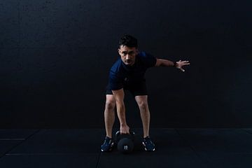 Ein Mann, der in einem Fitnessclub trainiert und Gewichte hebt von Bob Janssen