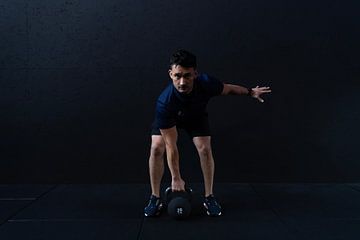 A man working out at a fitness club, lifting weights by Bob Janssen