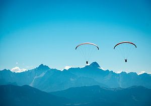 Deux parapentistes devant un panorama alpin