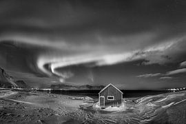 Holzhaus mit Polarlicht auf den Lofoten in Norwegen in schwarz-weiss.