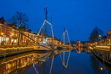 Decorated traditional fishing boats in the harbour of Dokkum at night in the Netherlands by Eye on You