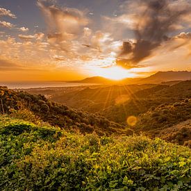 Beautiful sunbeams over the sea and mountains by Dafne Vos