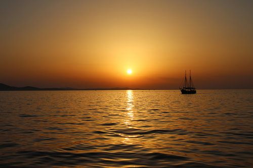 Zonsondergang op zee uitkijkend in de verte