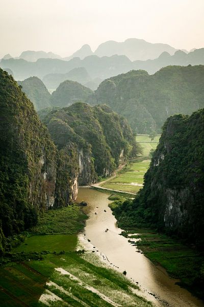 Aussichtspunkt in Tam Coc Vietnam mit hügeliger Landschaft und Booten auf dem Wasser. von Twan Bankers