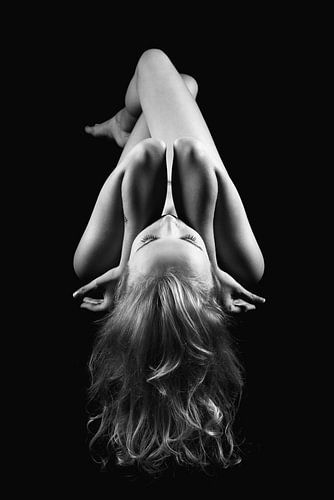 Feminine: nude on a black table