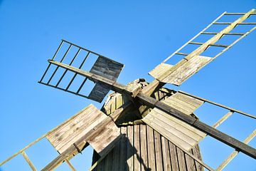 Vieux moulin à vent en bois dans un paysage idyllique sous un ciel bleu