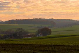 Colourful sunrise on a misty morning among the meadows in autumn by Kim Willems
