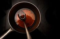 pot en lepel met runderbouillon tijdens het koken van een rode wijnmorelsaus op een zwart fornuis, d van Maren Winter thumbnail