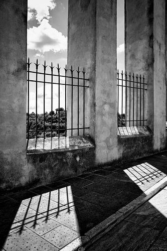 Hekwerk met zijn schaduw in Pitigliano, Toscane, Italië. (zwart-wit)