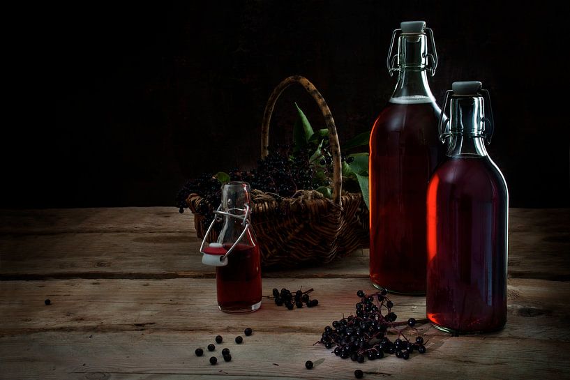 jus de sureau noir (Sambucus nigra) fait maison en bouteilles et baies dans un panier sur des planch par Maren Winter