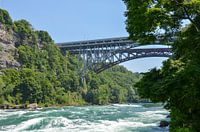 Bruisende stroomversnellingen onder een brug