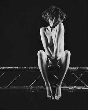 Schöne nackte Frau, die auf einer Bühnentraverse sitzt. #9681 von Photostudioholland