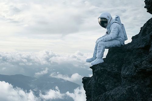 Astronaut zit op een rotspiek