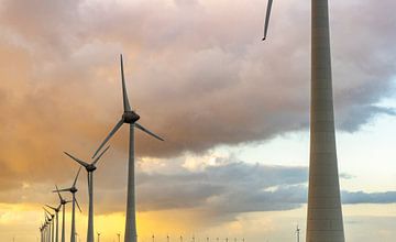 Windturbines in een windpark tijdens zonsondergang