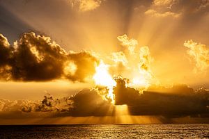 Stimmungsvoller Sonnenuntergang hinter Wolken am Meer