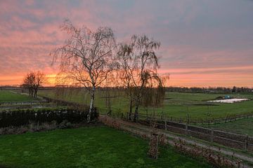 Orange sunset over farmland and trees at the Dutch countryside n van Werner Lerooy