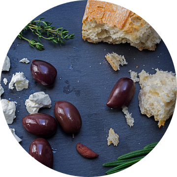 kalamata olijven en fetakaas uit Griekenland met brood en kruiden op een donkere achtergrond van lei van Maren Winter