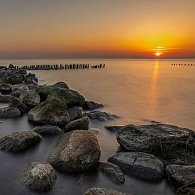 Golfbreker van stenen en palen in het IJsselmeer bij Enkhuizen tijdens mooie zonsopkomst van Bram Lubbers
