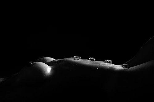 Artistieke naaktfoto vrouw met ijsblokjes – sensuele lowkey fotografie