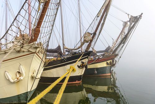 Oude zeilschepen aan de kade in Kampen in de mist