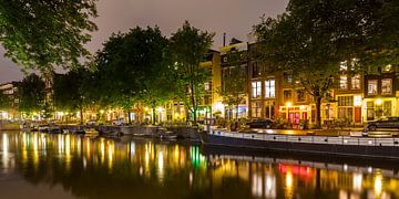 Gracht in de oude binnenstad van Amsterdam bij nacht van Werner Dieterich