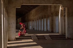 Interaction entre deux jeunes moines dans le couloir d'un temple à Bagan