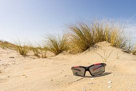 The lost sunglasses on the deserted beach by John Duurkoop