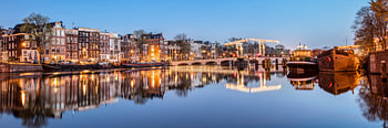 Grachtenhuizen aan de Amstel rivier in Amsterdam,  Nederland.