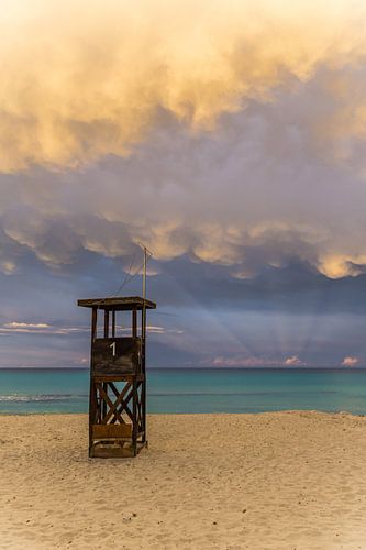 Mallorca, De hemel van de zonsondergang boven strandwachtershuis bij zandstrand van mallorca