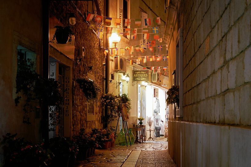 historical alley in the old town of Porec in Croatia in the evening by Heiko Kueverling