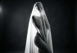 A veiled nude in a sheer white cloth by Retinas images