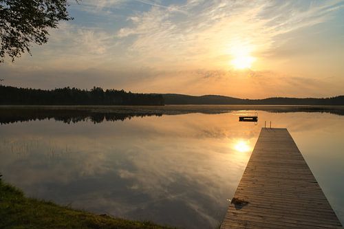 Loopbrug, naar de zonsopgang, reikend in een Zweeds meer