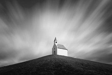 Kerkje in zwart-wit onder bewegende wolken