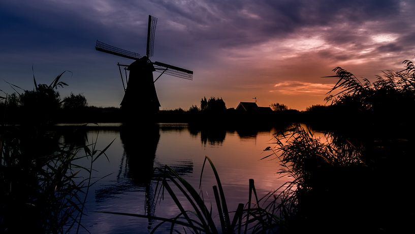 Silhouette of a mill at sunset in Kinderdijk by Michel Seelen