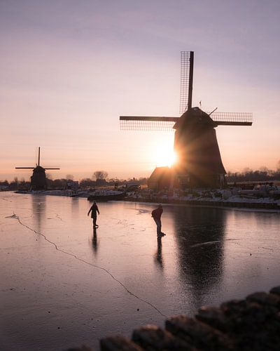 Patinage sur glace naturelle près des moulins sous le soleil hivernal