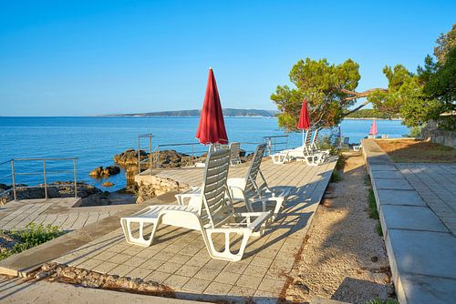 Parasols en ligstoelen op het strand van Krk in Kroatië
